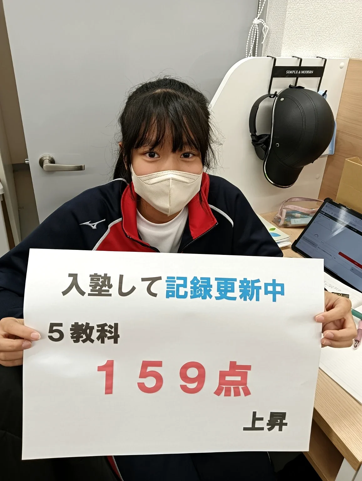 入塾後、5教科159点上昇と書かれた実績ボードを持つ生徒