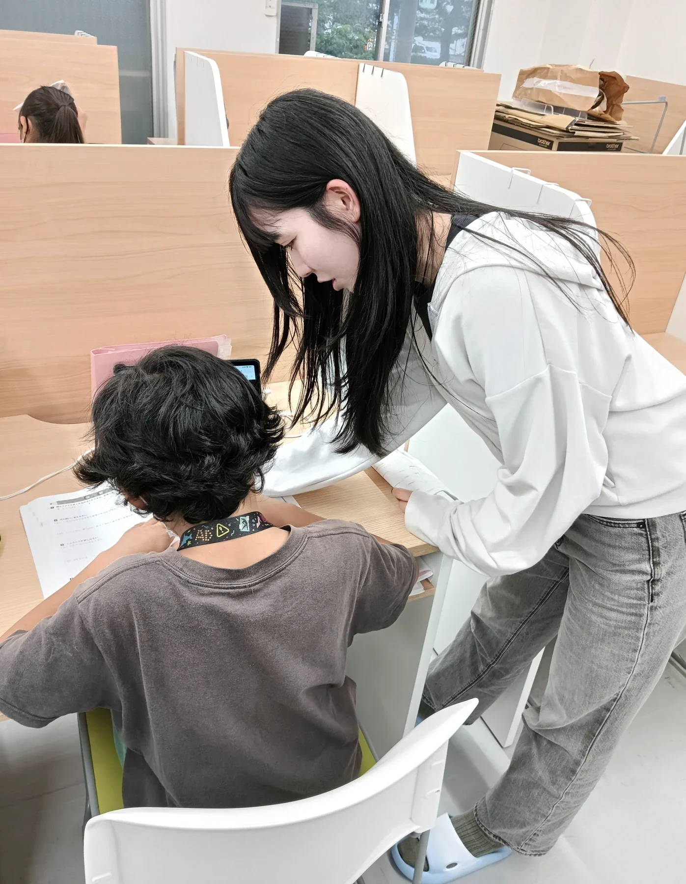子どもの手元を確かめながら個別にフォローするスタッフ